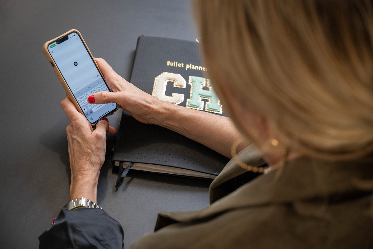 Person tippt auf einem Smartphone, daneben ein Notizbuch – Symbol für digitale Kommunikation und den Newsletter von Make It Matter.