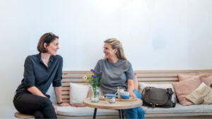 Zwei Kommunikationsberaterinnen von Make It Matter im Gespräch bei Kaffee – Symbol für Kommunikation, Strategie und Zusammenarbeit auf Augenhöhe.